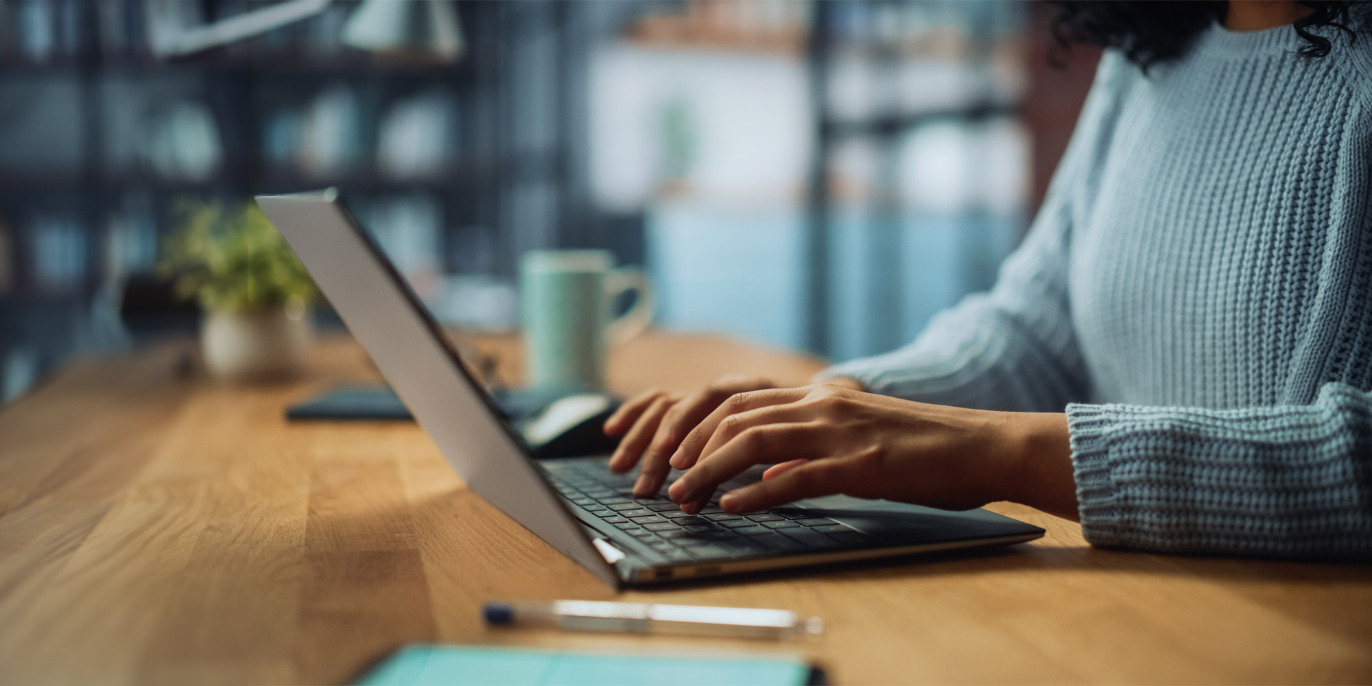 Person typing into a laptop to contact the dental practice