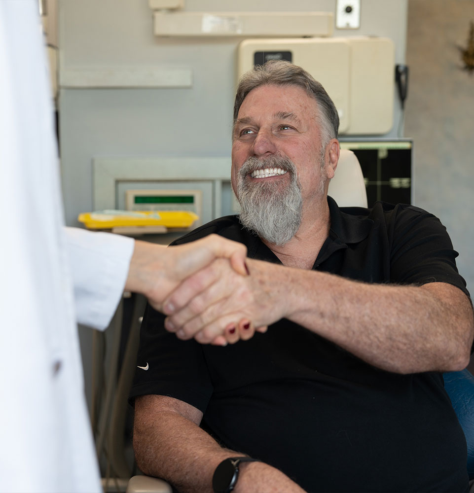 patient shaking hands with doctor within the dental center